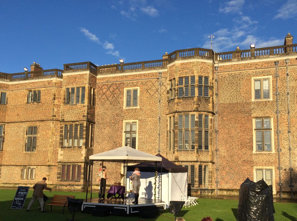 Actors setting up the stage, in character, before the downpour